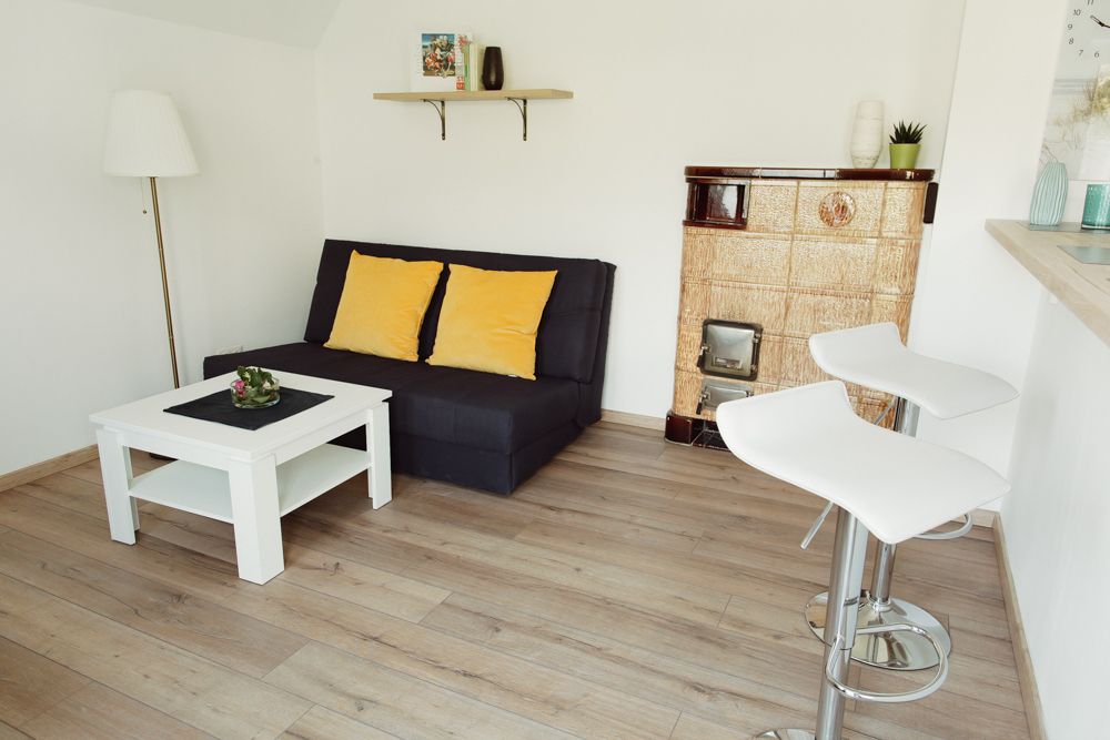 Moderní obývací pokoj s pohovkou, konferenčním stolkem, barovými stoličkami a krbem.