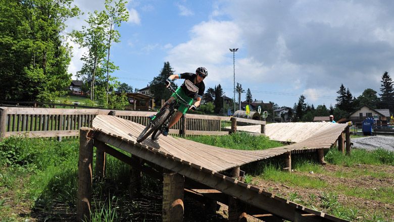Dítě jedoucí na dřevěné rampě v Bikeparku Semmering.