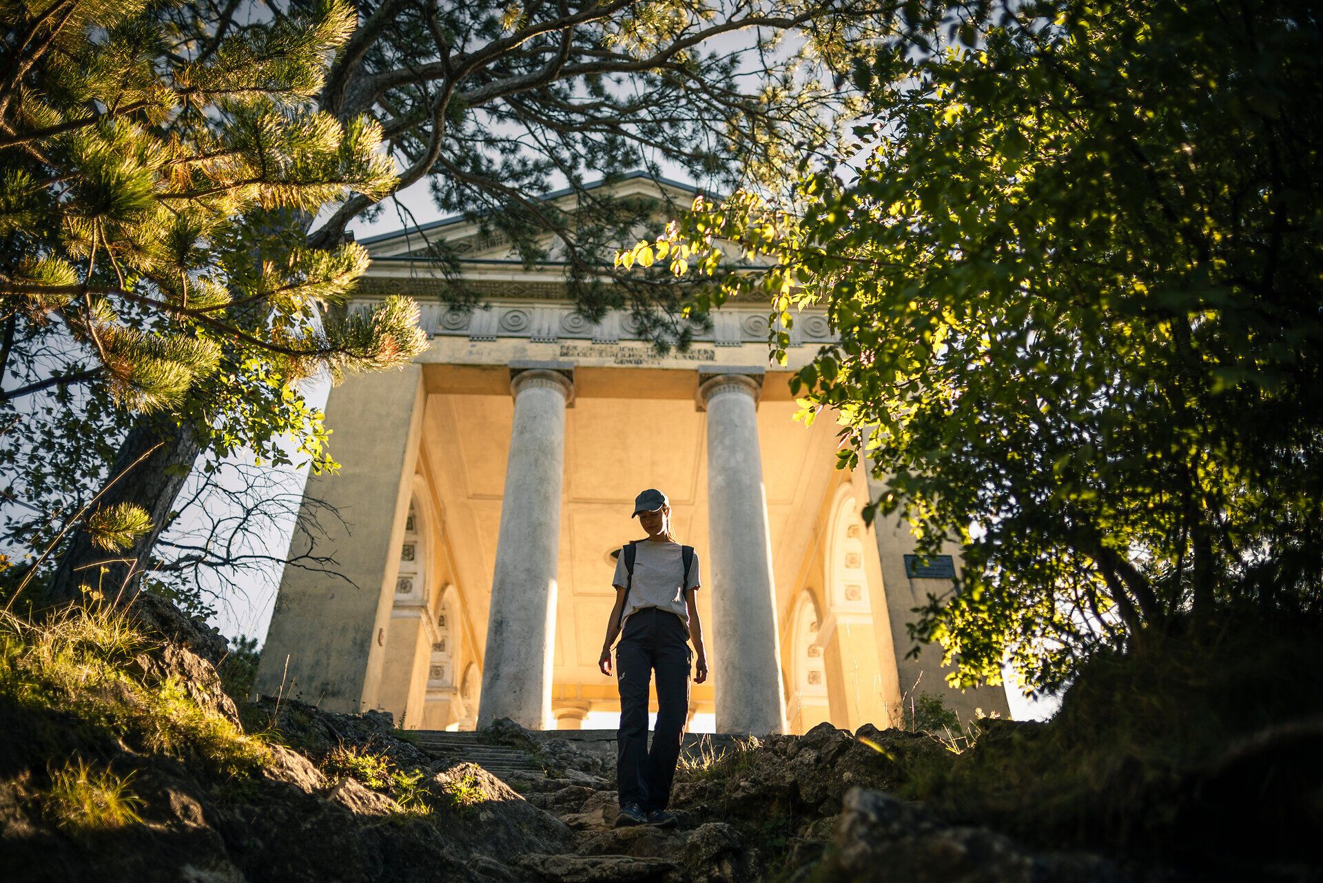Frau wandert bergab, Husarentempel im Hintergrund