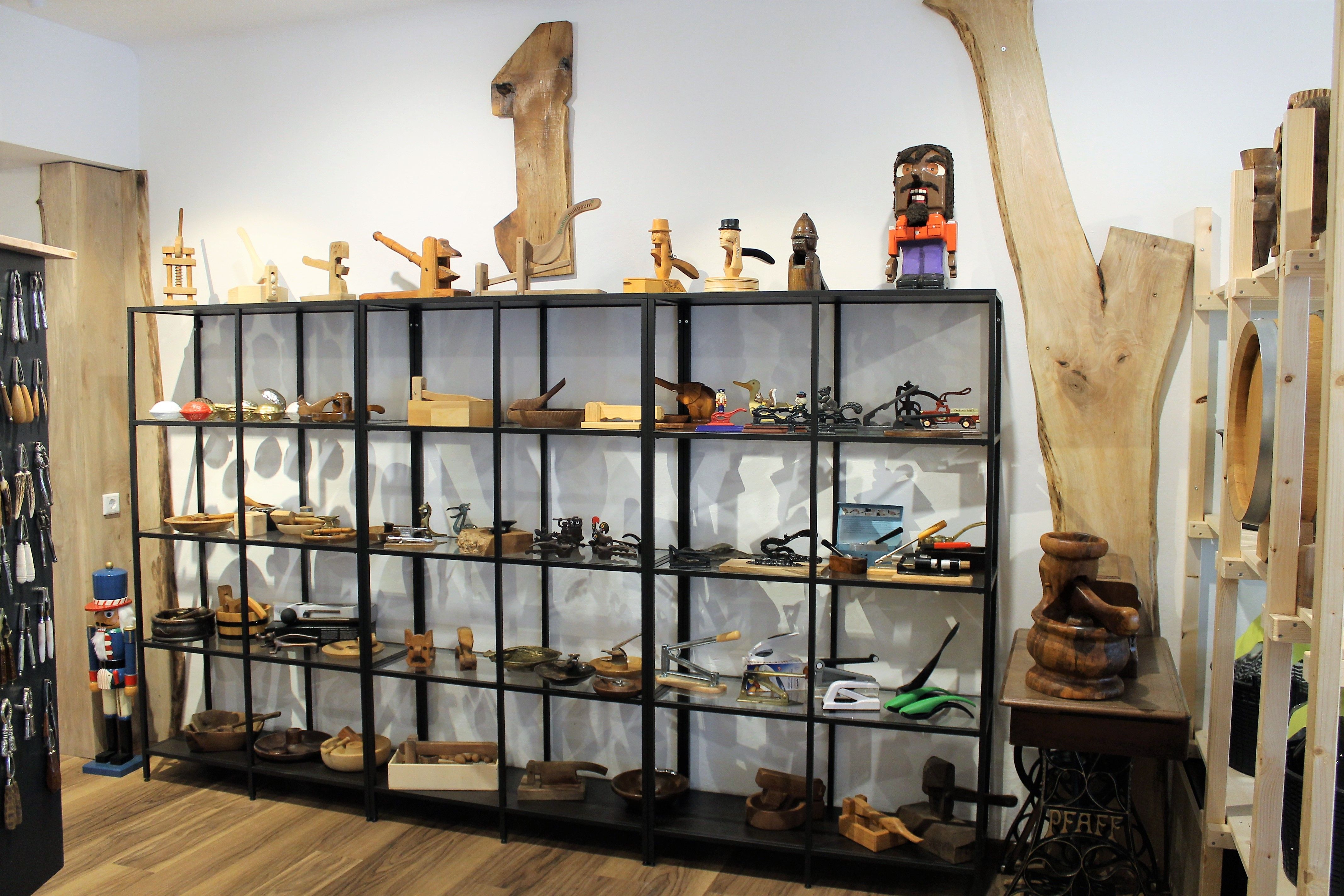 Police s dřevěnými předměty a nářadím v showroomu.