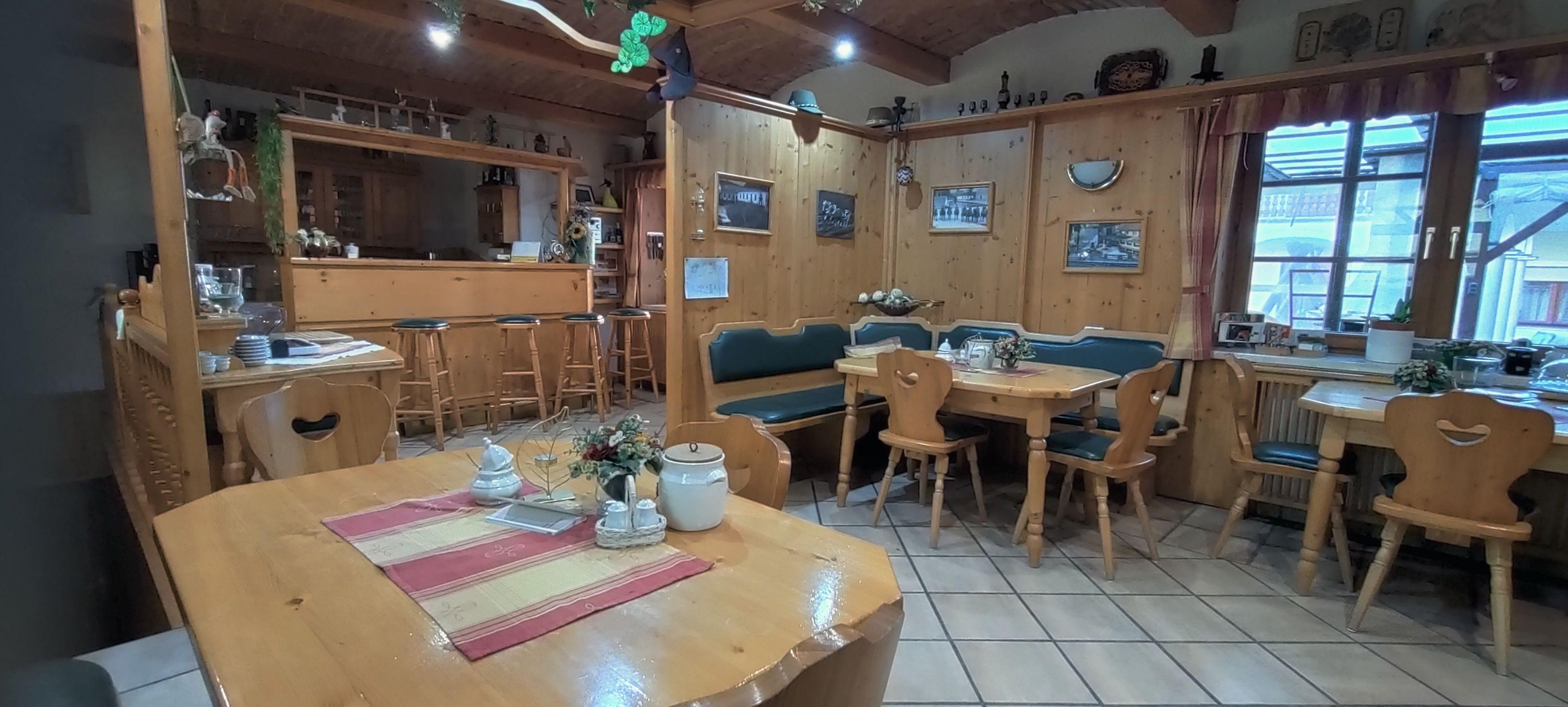 Útulná snídaňová místnost s dřevěným nábytkem a dekoracemi.