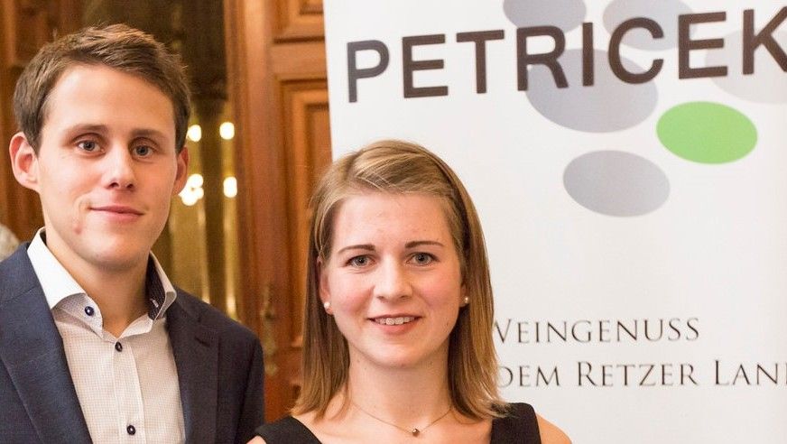 Dva lidé před transparentem s nápisem "PETRICEK".