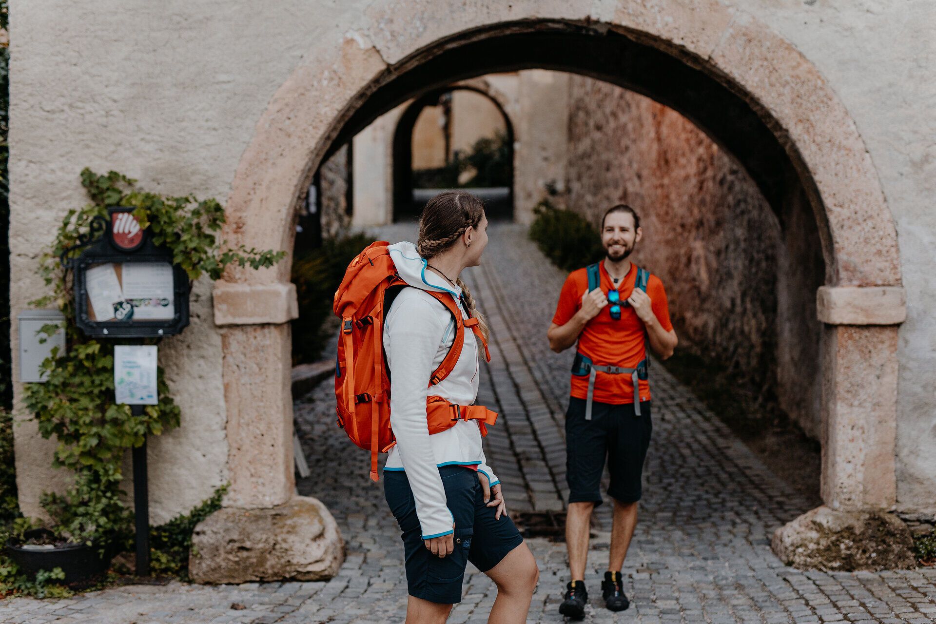 Dva turisté stojí u vstupní brány do hradu Gloggnitz