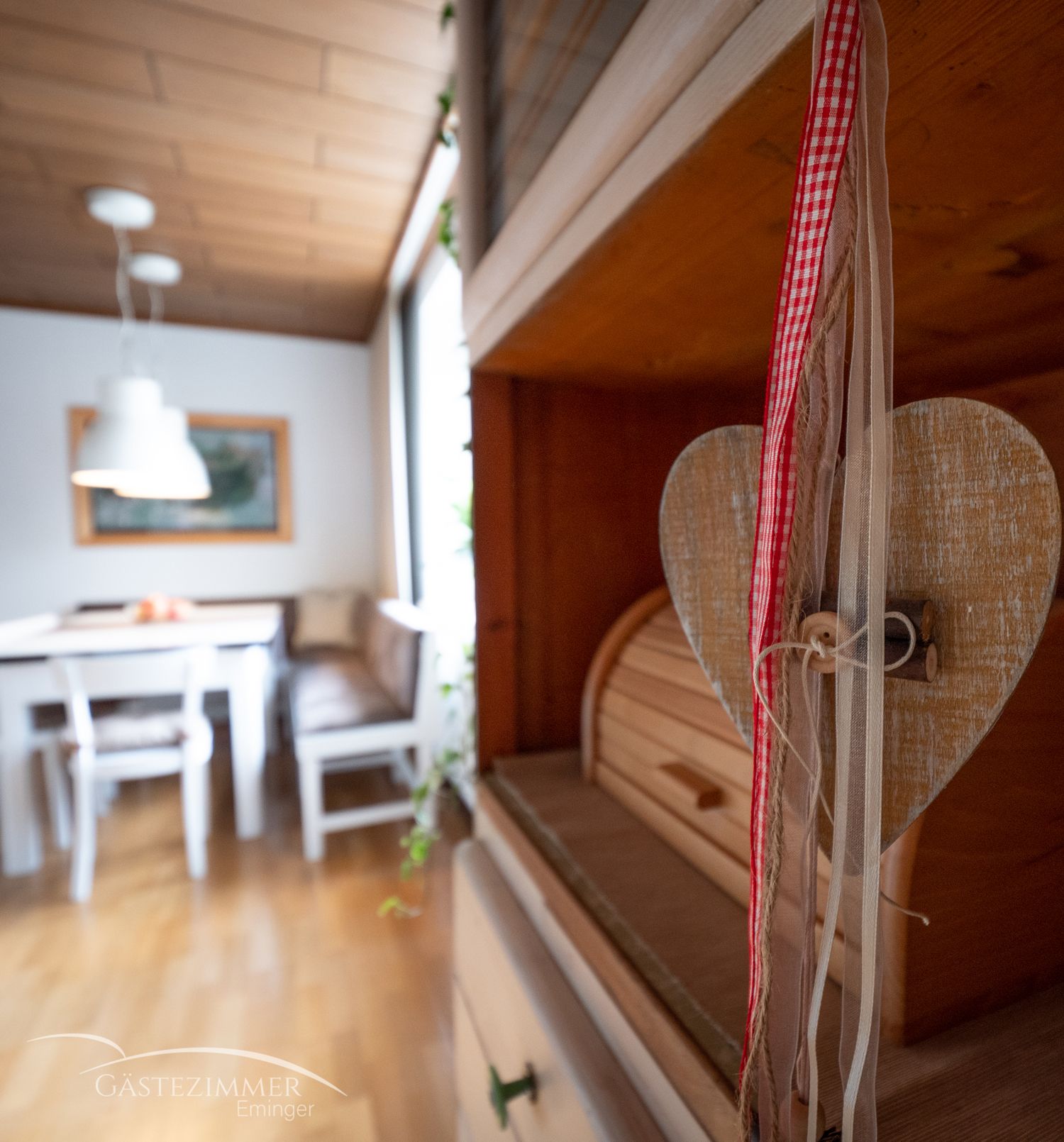 Útulná kuchyně s dřevěným nábytkem a srdcovými dekoracemi.