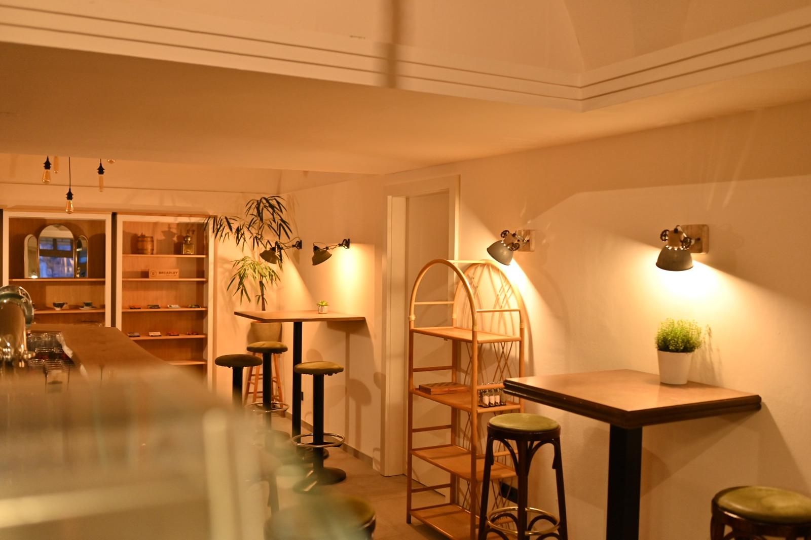 Pohled do interiéru útulné kavárny s dřevěným nábytkem a teplým světlem.