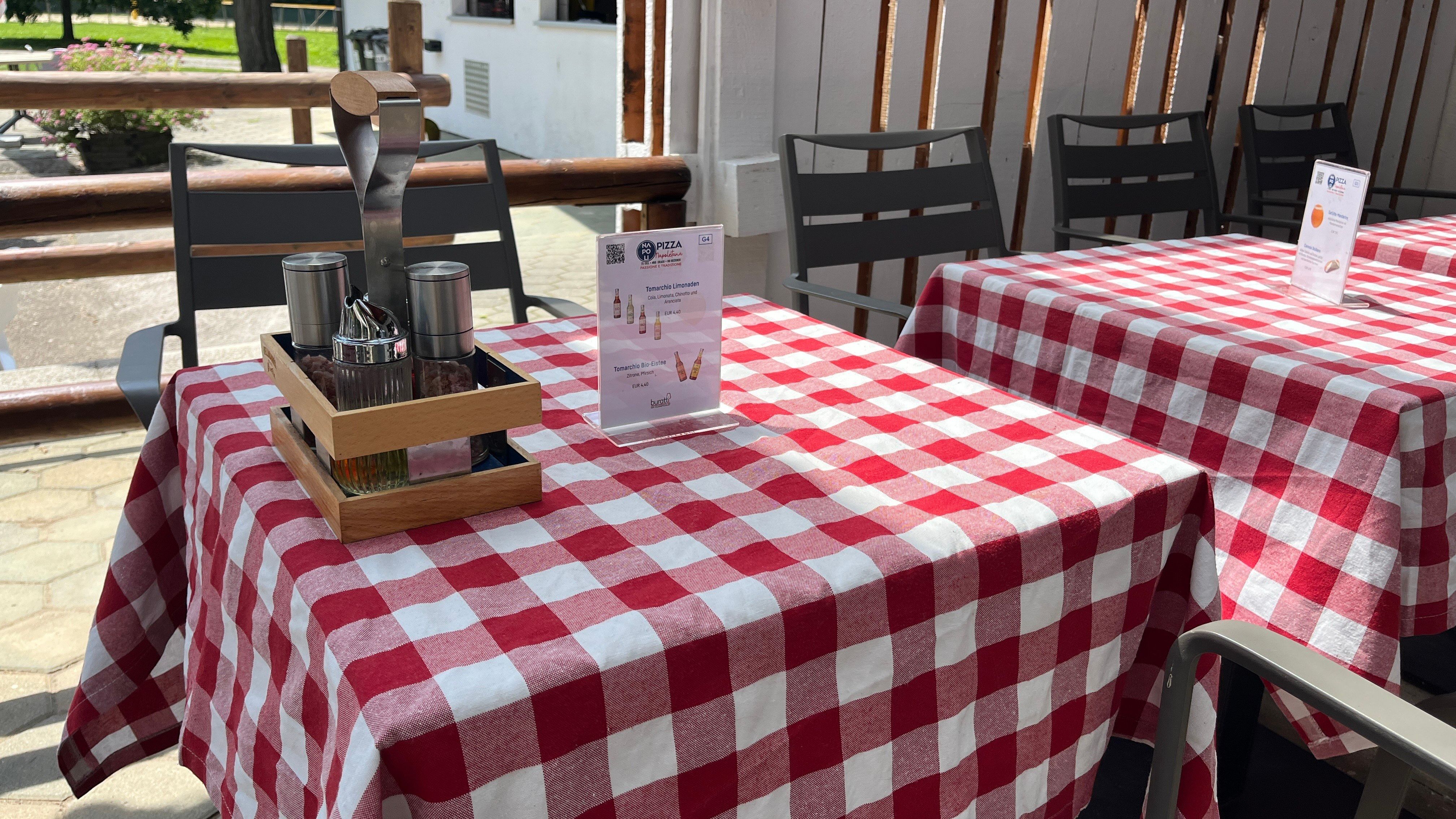 Prostírání stolu s červeným ubrusem a doporučením na jídlo.