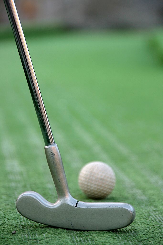 Minigolfové hole před zelenou trávou 