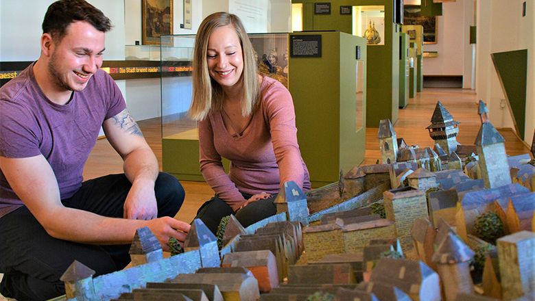 Dva lidé si prohlížejí model města v muzeu.