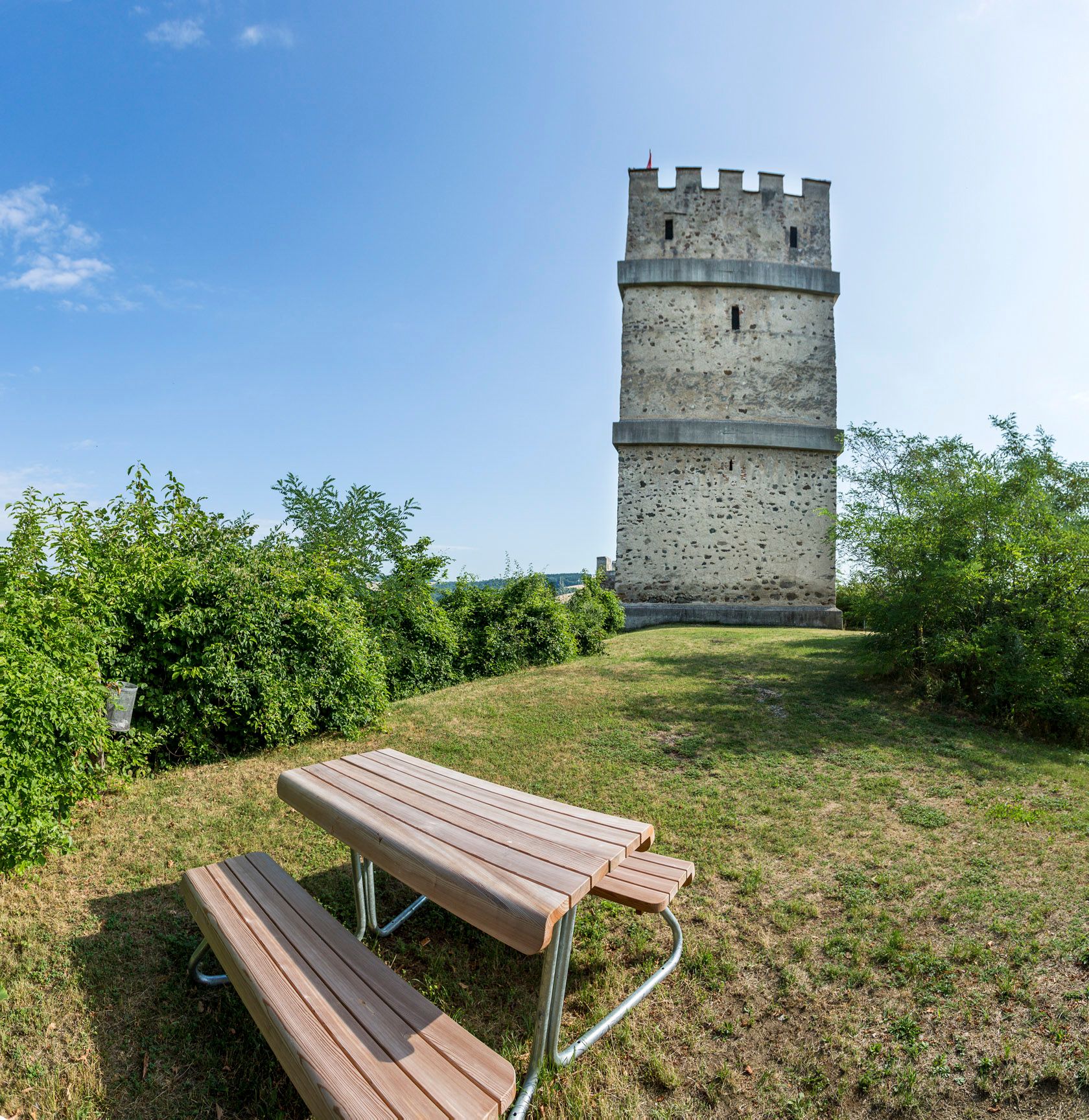 Požární věž zříceniny hradu Kirchschlag s piknikovým stolem v popředí.