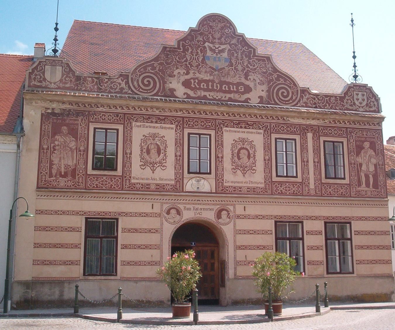 Historická radnice v Drosendorfu-Zissersdorfu se zdobnými malbami na fasádě.