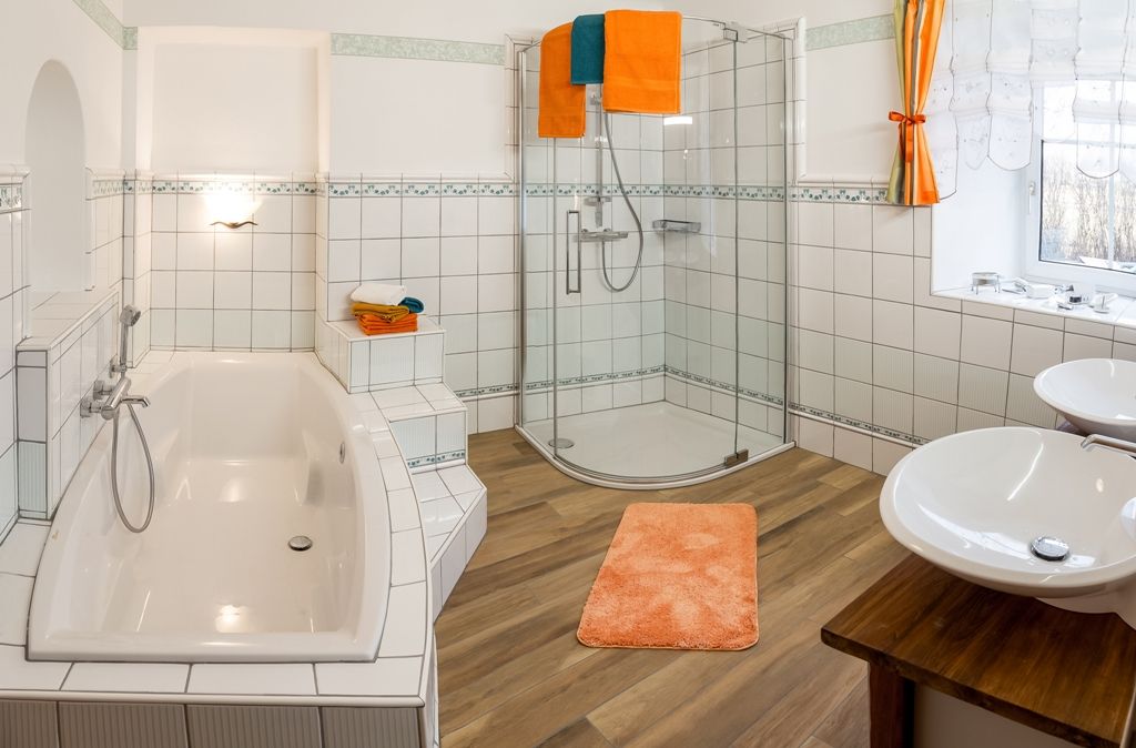 Moderní koupelna s vanou, sprchovým koutem a dvojitým umyvadlem.
