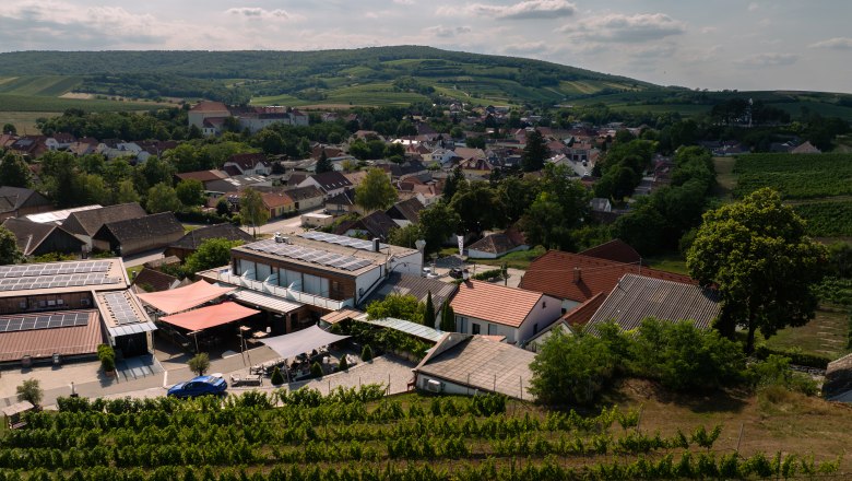 Letecký pohled na vinařství s okolními budovami a vinicemi.