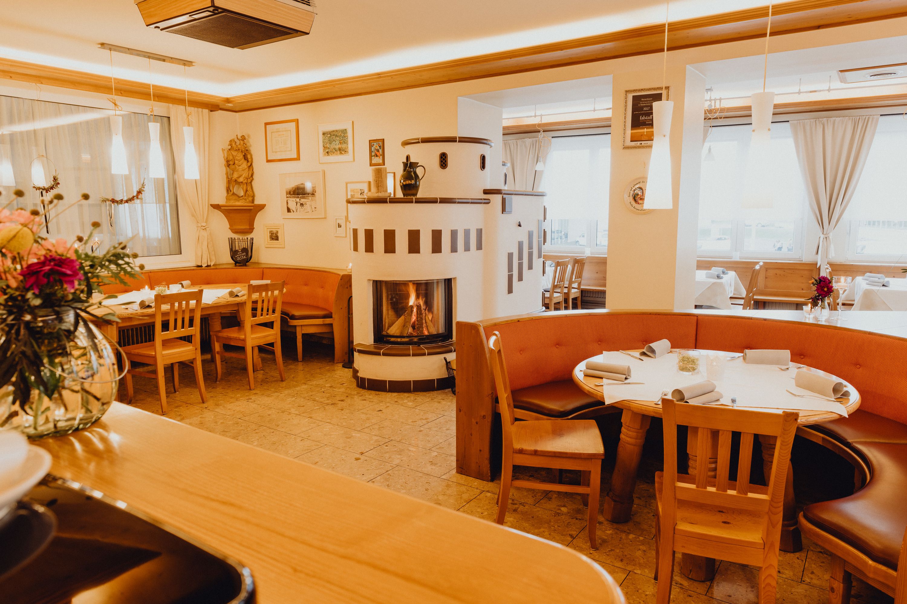 Útulná restaurace s krbem a dřevěným nábytkem ve Vídeňských Alpách.