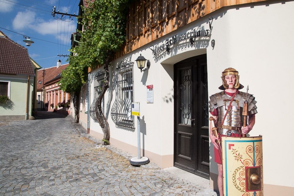 Před budovou v Traismaueru stojí lepenkový stojan s římským vojákem.