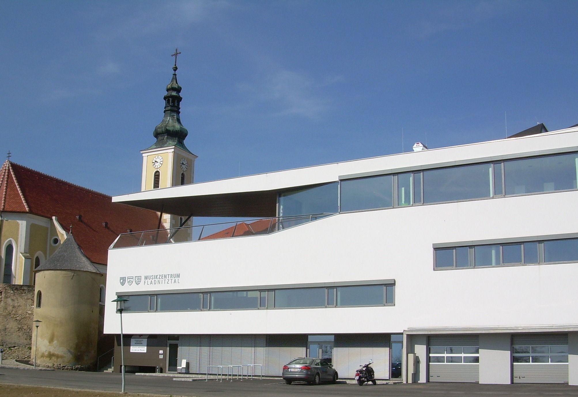 Moderní budova s kostelní věží v pozadí ve Wölblingu.
