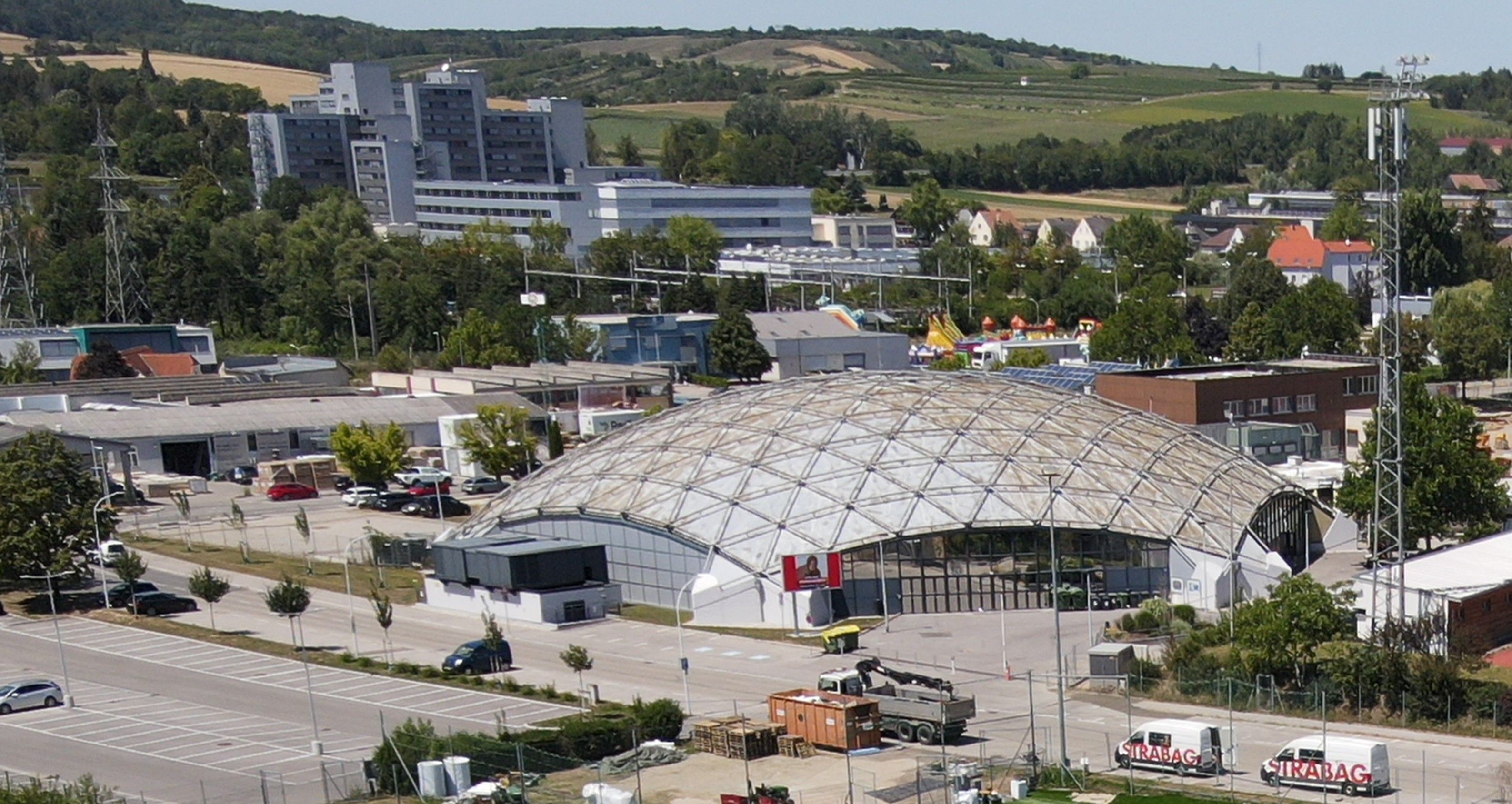 Letecký pohled na sportovní halu v Hollabrunnu s okolními budovami a krajinou.