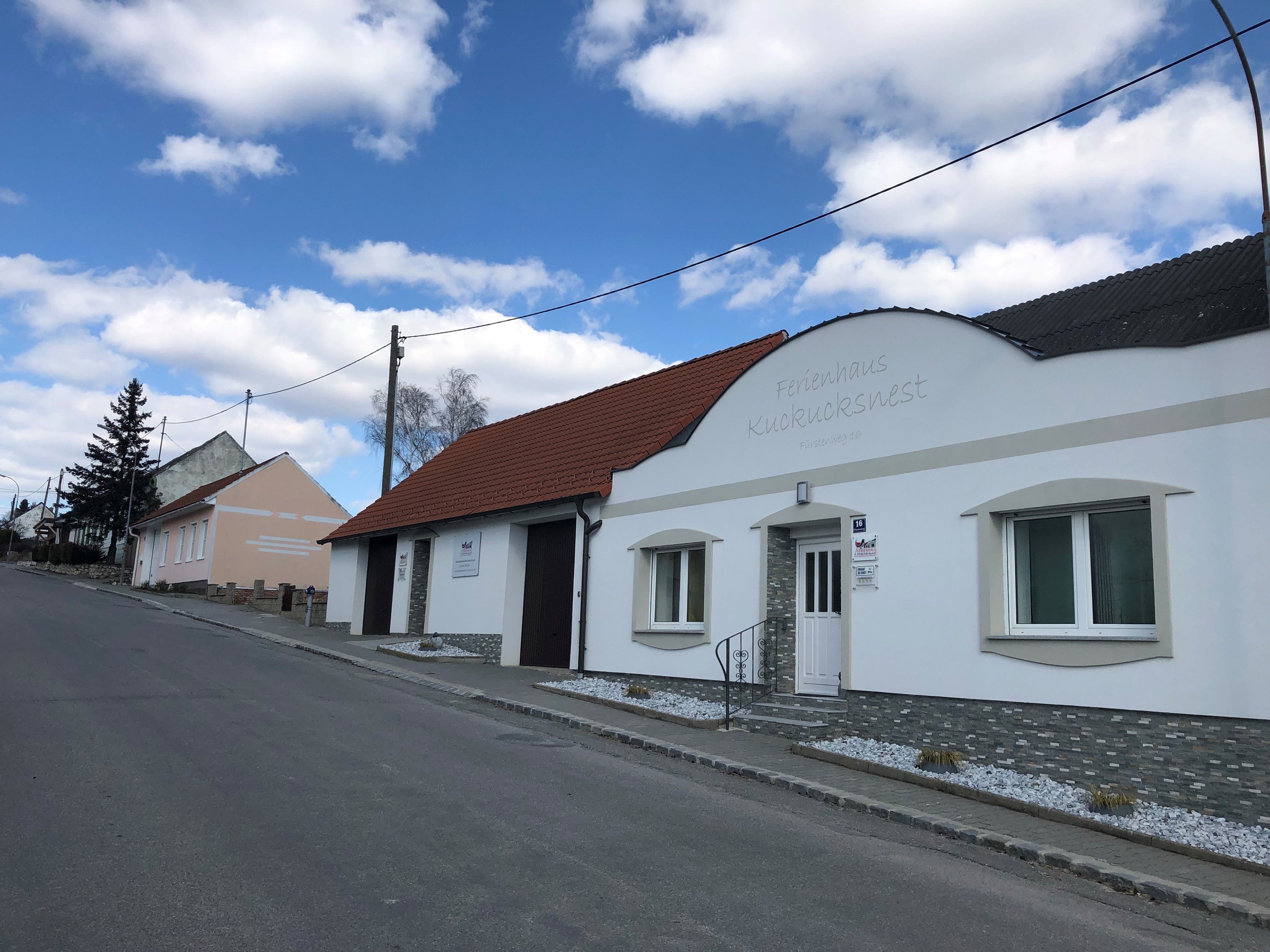 Ulice s rekreačním domem Kuckucksnest a modrou oblohou.