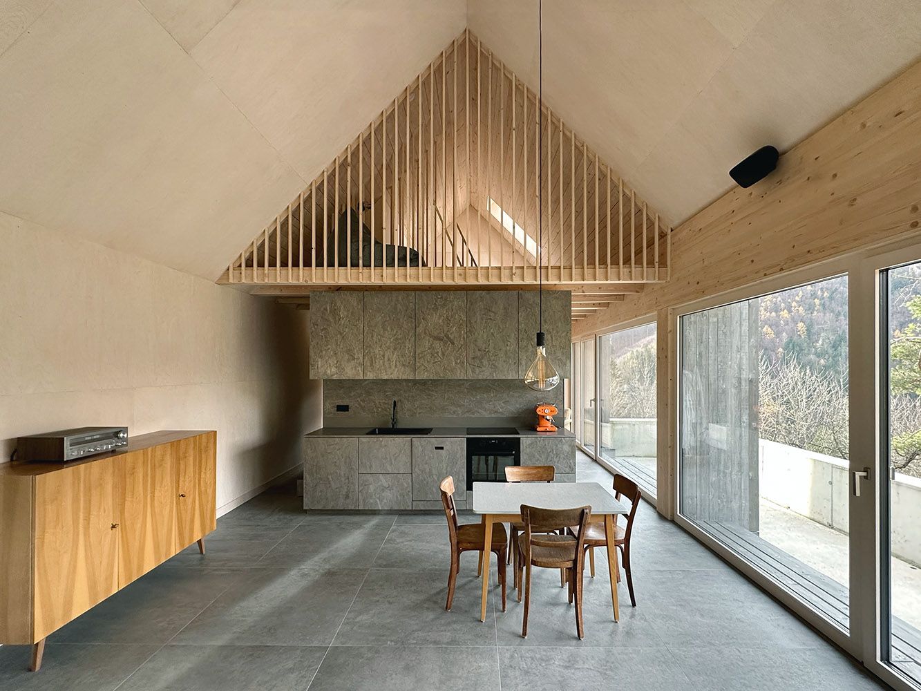 Moderní otevřená kuchyně s dřevěnými prvky a velkými okny.