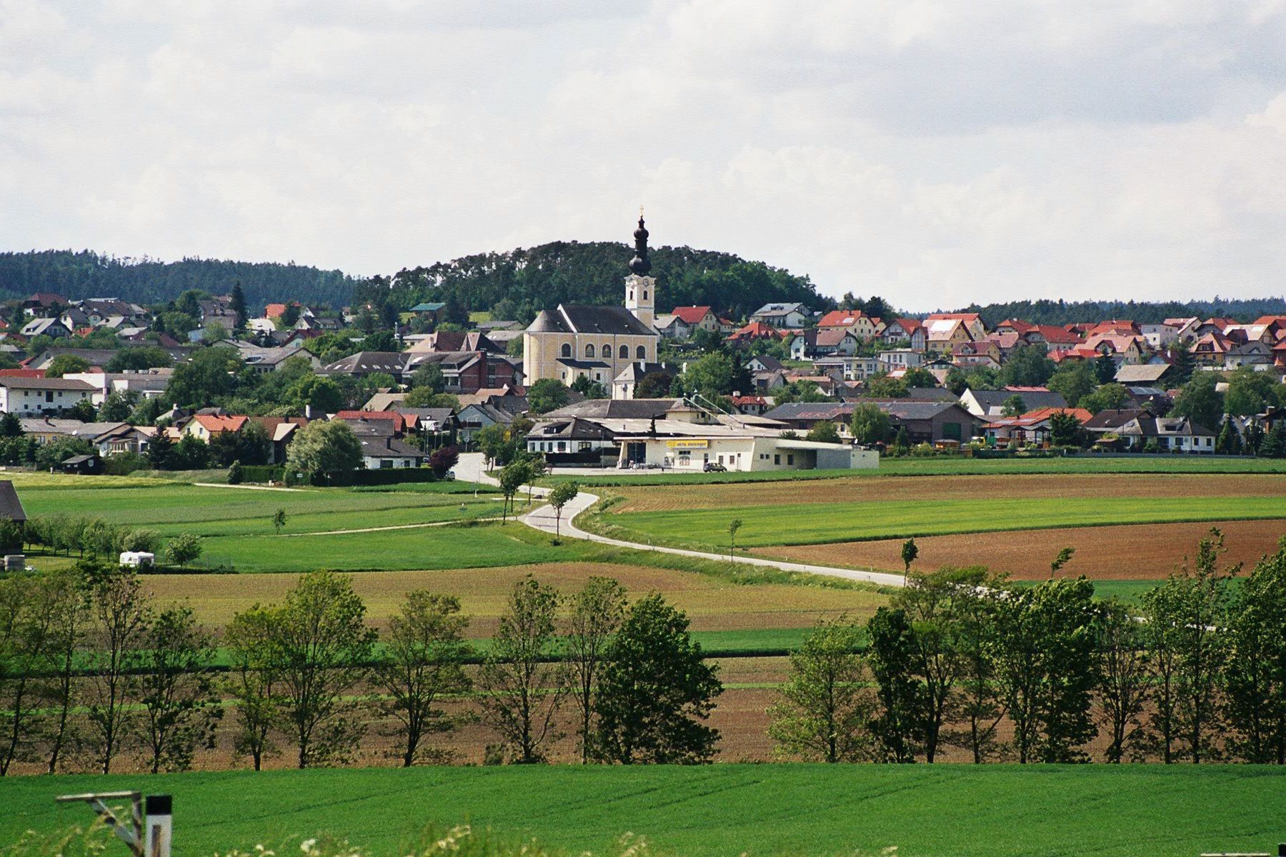 Panorama tržního města Karlstetten s kostelem a okolními poli.