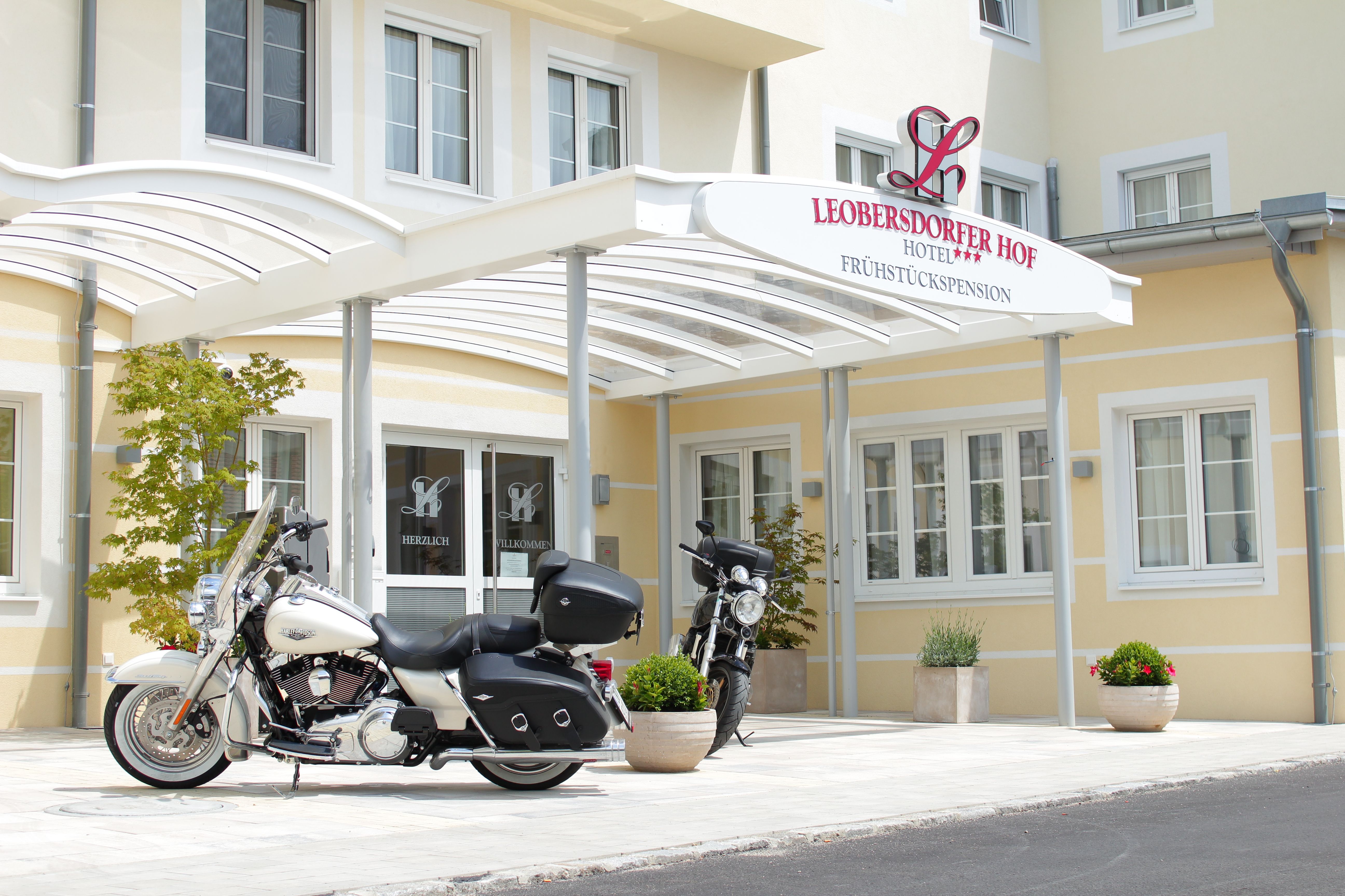 Dvě motorky před vchodem do hotelu Leobersdorfer Hof.