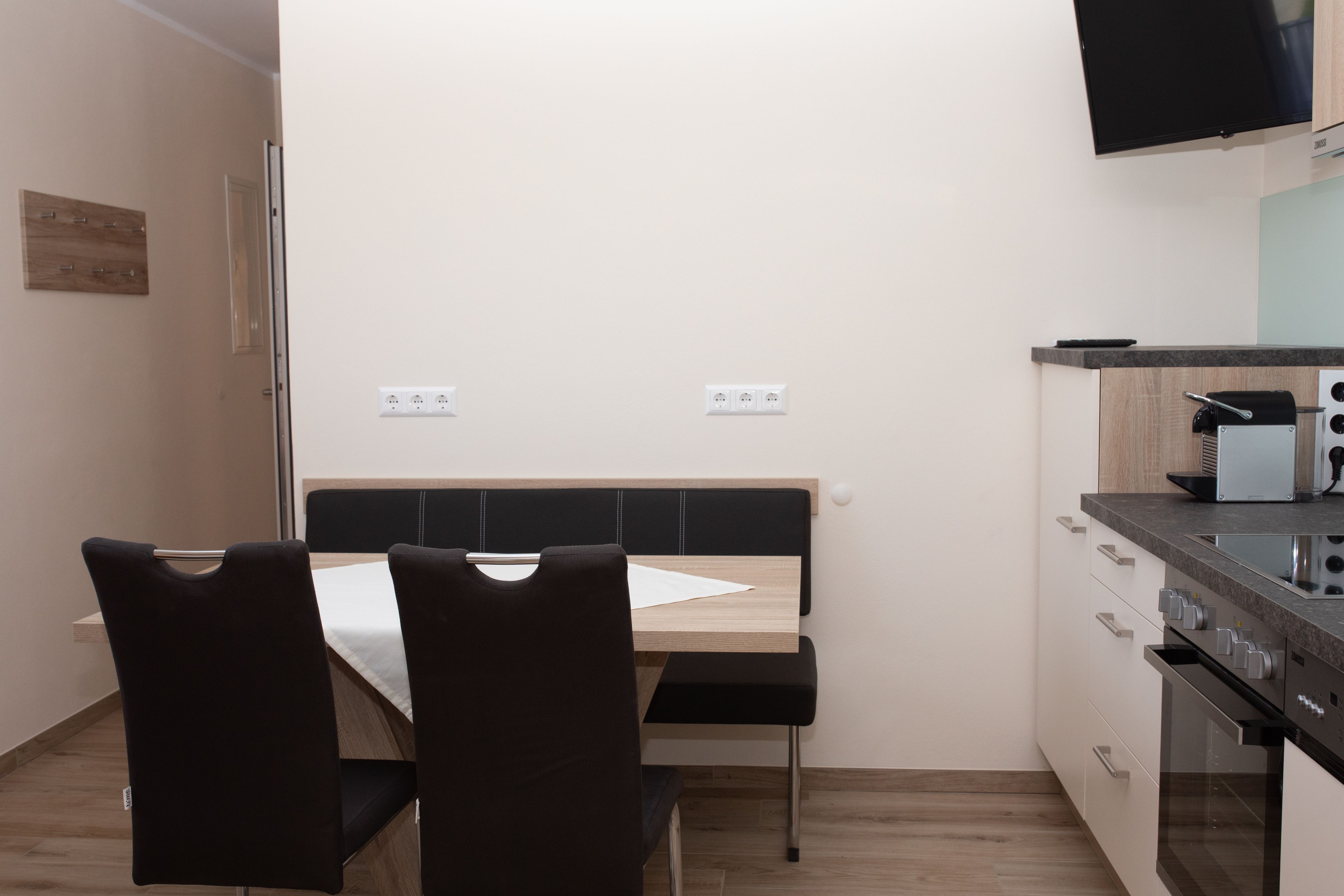 Jídelní kout se stolem, židlemi a kuchyňským koutem.