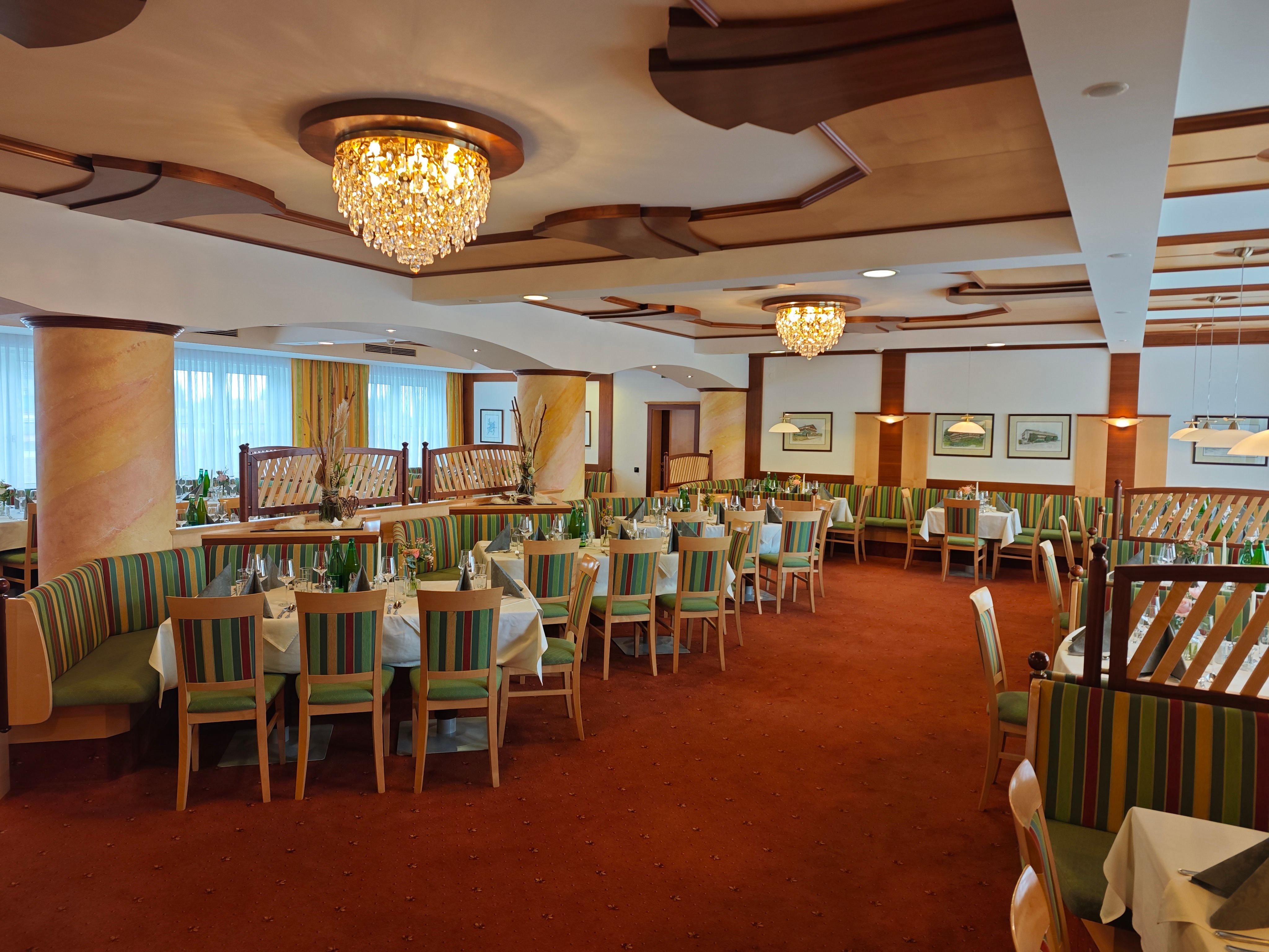 Elegantní jídelna s lustry a prostřenými stoly v hotelu Thier.