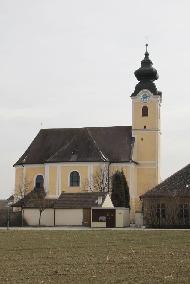 Farní kostel v Langenrohru se žlutou fasádou a cibulovou kopulí.