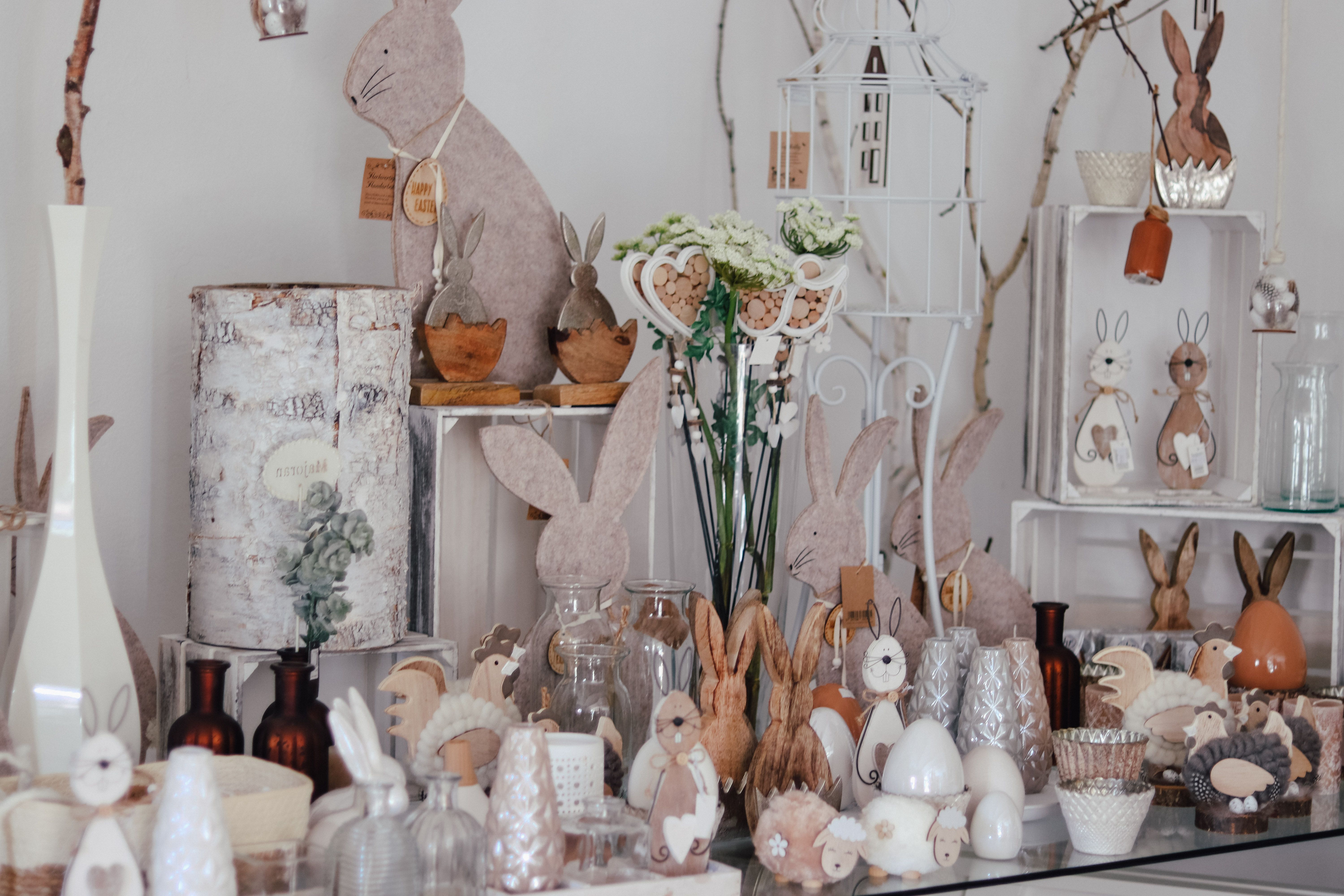 Dekorativní velikonoční zajíčci a jarní dekorace naaranžované na stole.