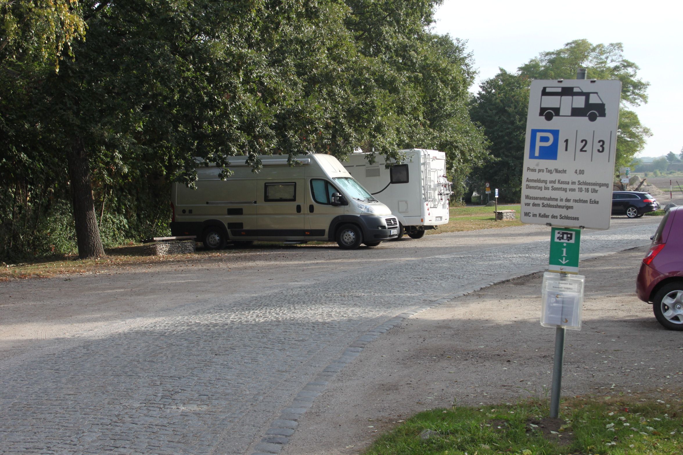 Parkoviště pro obytné vozy se dvěma zaparkovanými obytnými vozy a ukazatelem.