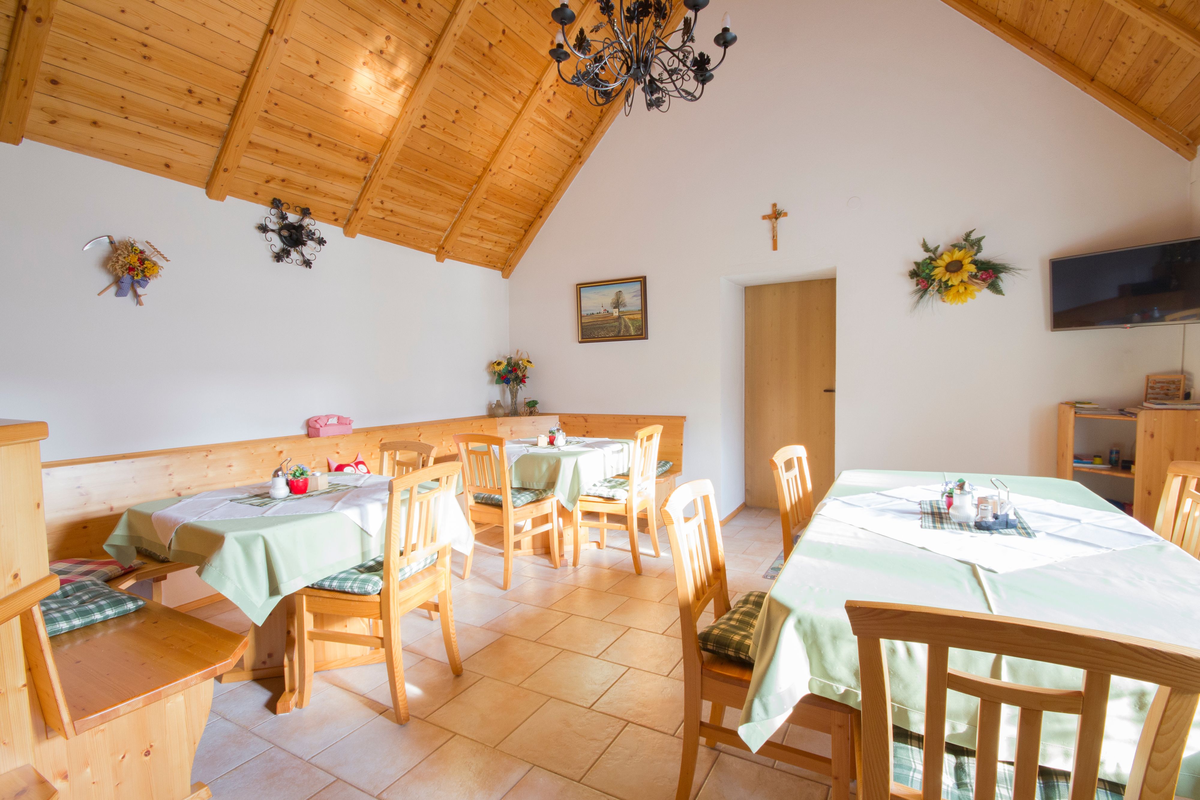 Útulný pokoj s dřevěným nábytkem a zdobenými stoly.