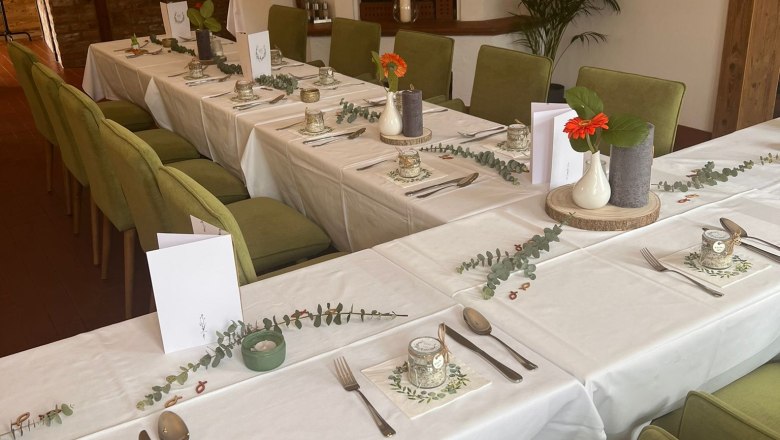 Elegantn&iacute; restaurace s prostřen&yacute;m stolem, zelen&yacute;mi židlemi a krbem.