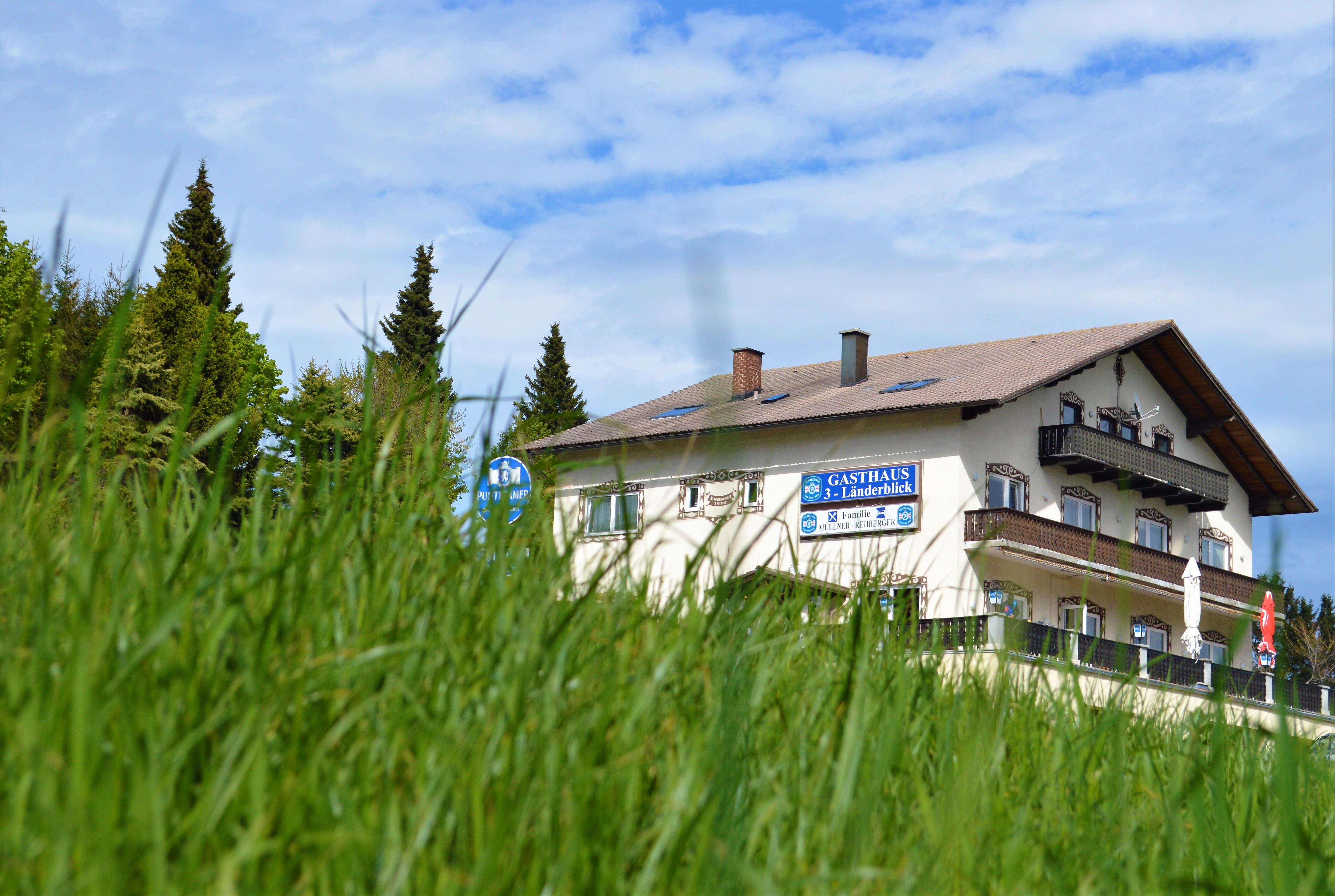 Gasthaus 3-Länderblick za loukou se stromy v pozadí.