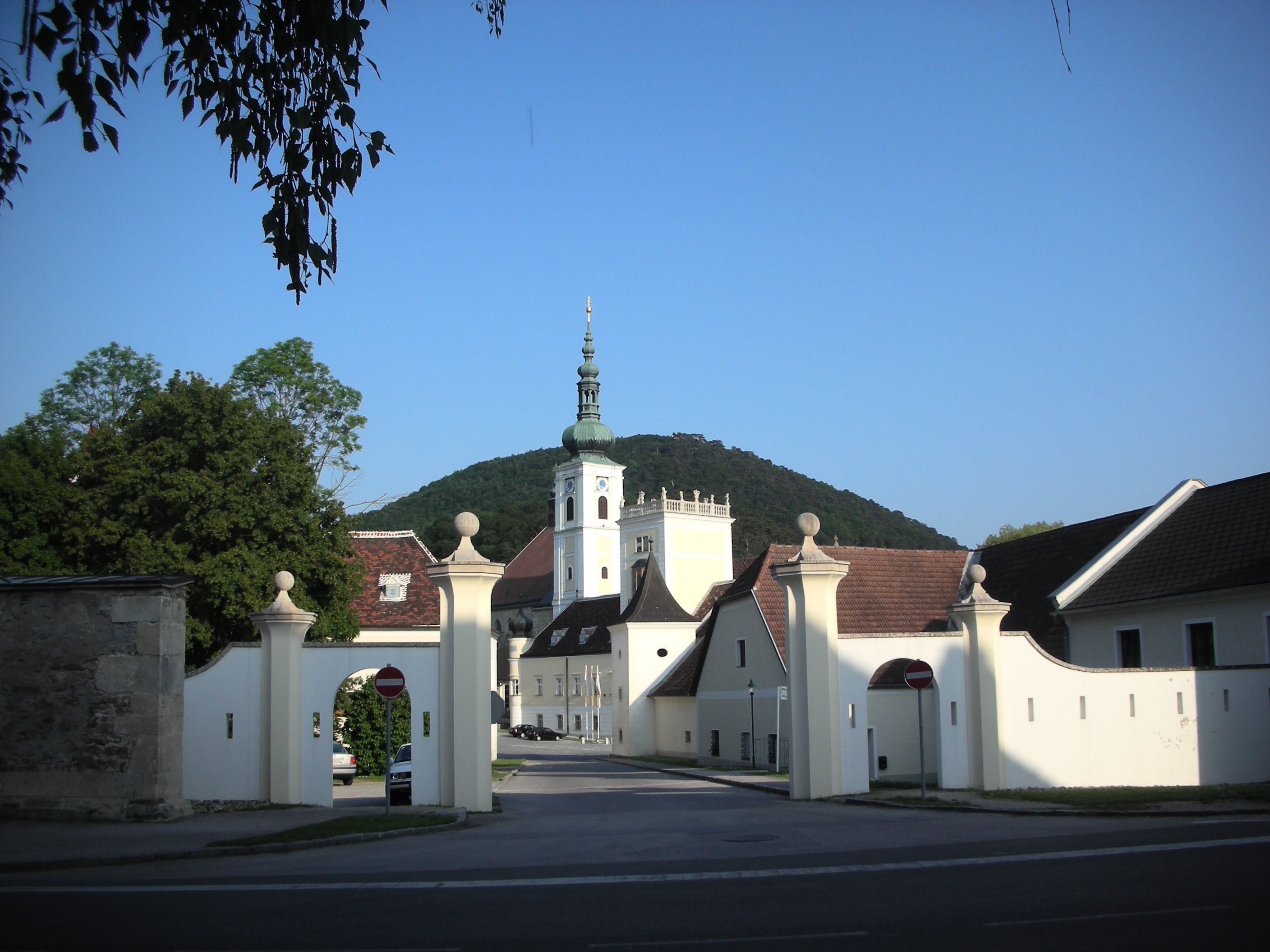 Vstupní brána opatství Heiligenkreuz s kostelní věží v pozadí.
