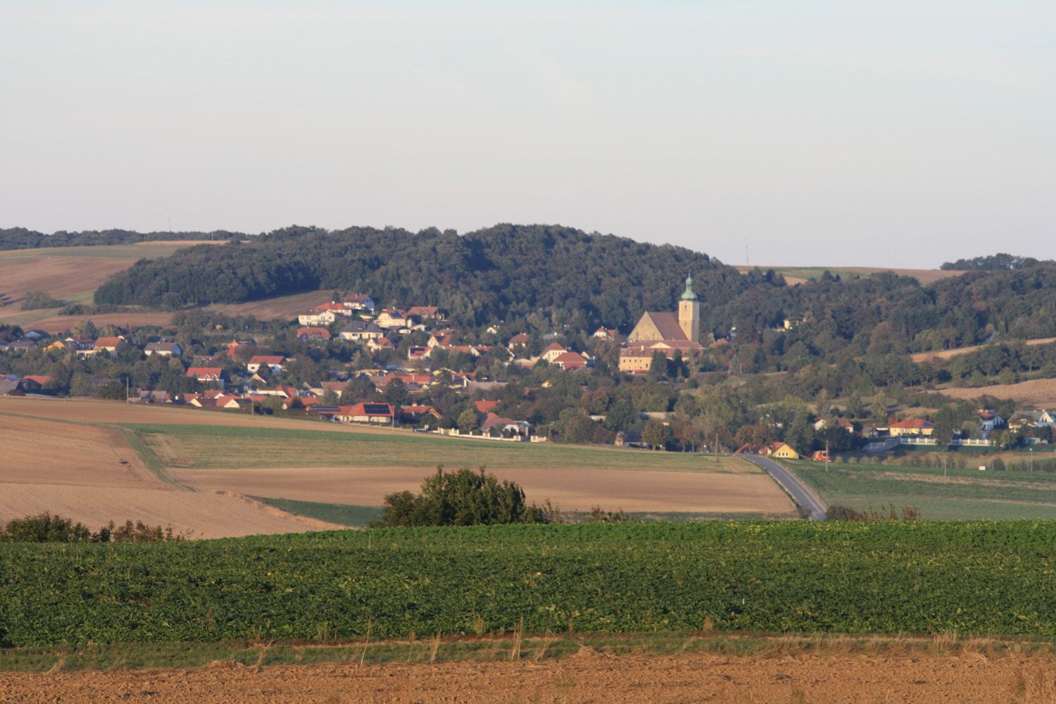 Panoramatický pohled na Großrußbach s kostelem a okolními poli.