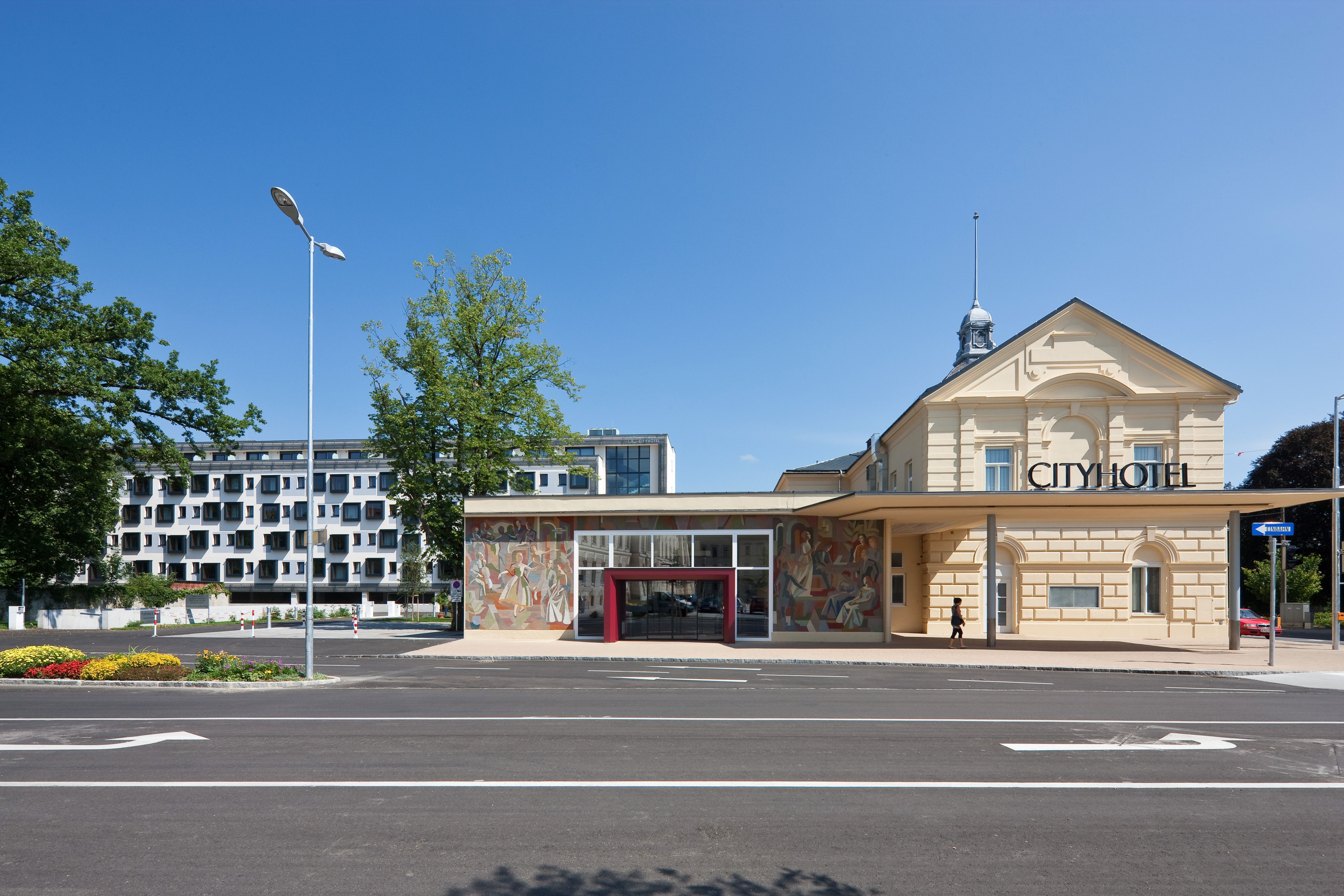 Pohled na Cityhotel D & C zvenčí s moderními a historickými částmi budovy.