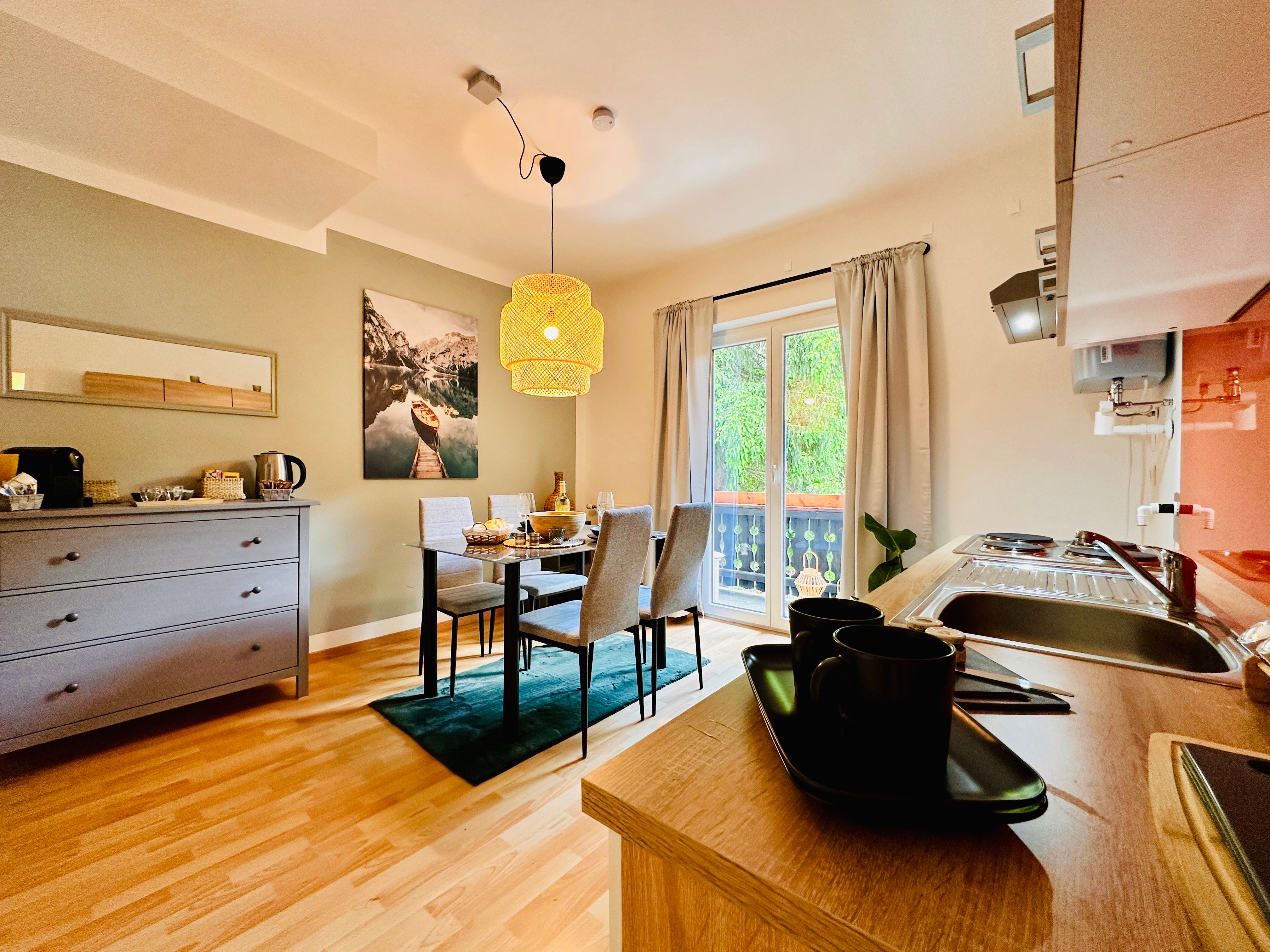 Útulný byt s jídelním stolem, kuchyňským koutem a balkonem.