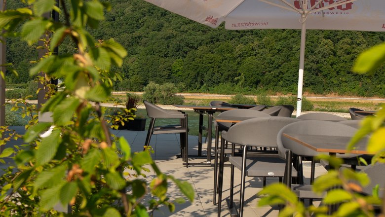 Stoly na terase se zelen&yacute;mi rostlinami