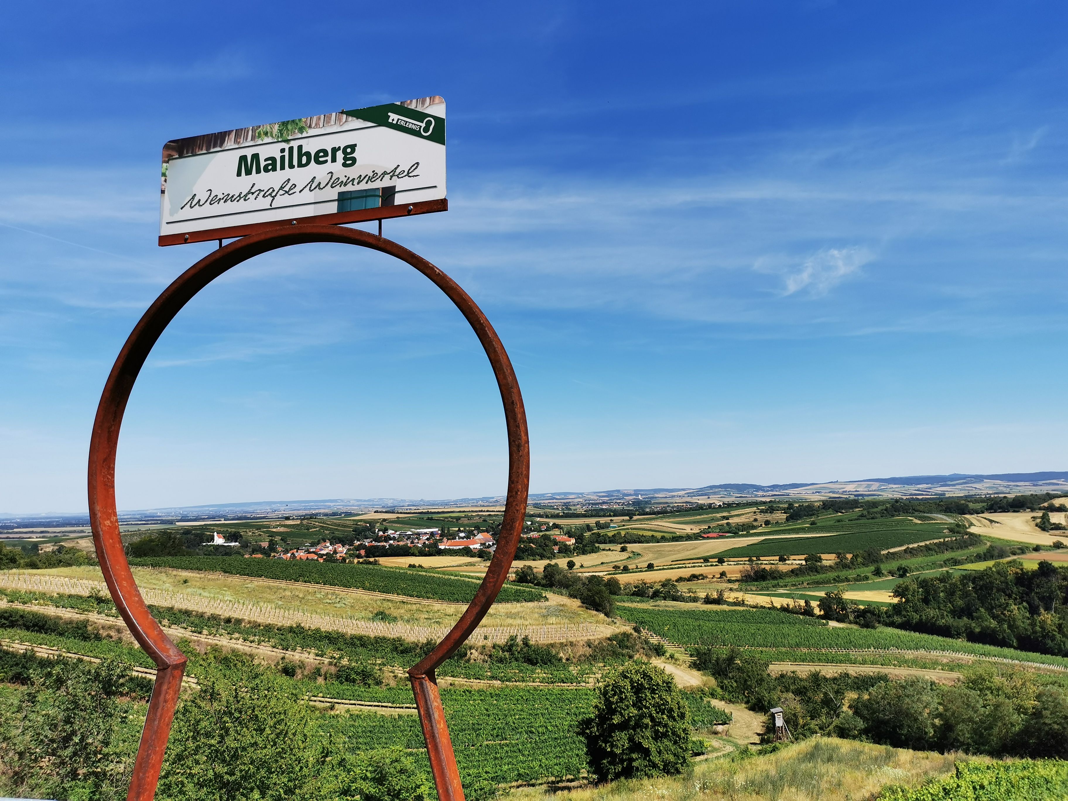 Krajina s vinicemi a nápisem "Mailberg vinařská cesta Weinviertel".