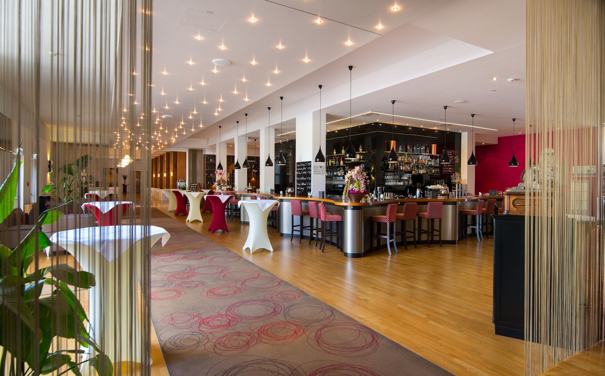 Elegantní hotelový bar s moderním nábytkem a stylovým osvětlením.