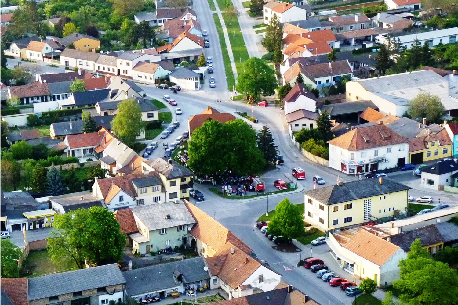 Letecký pohled na malé město s domy, ulicemi a stromy.