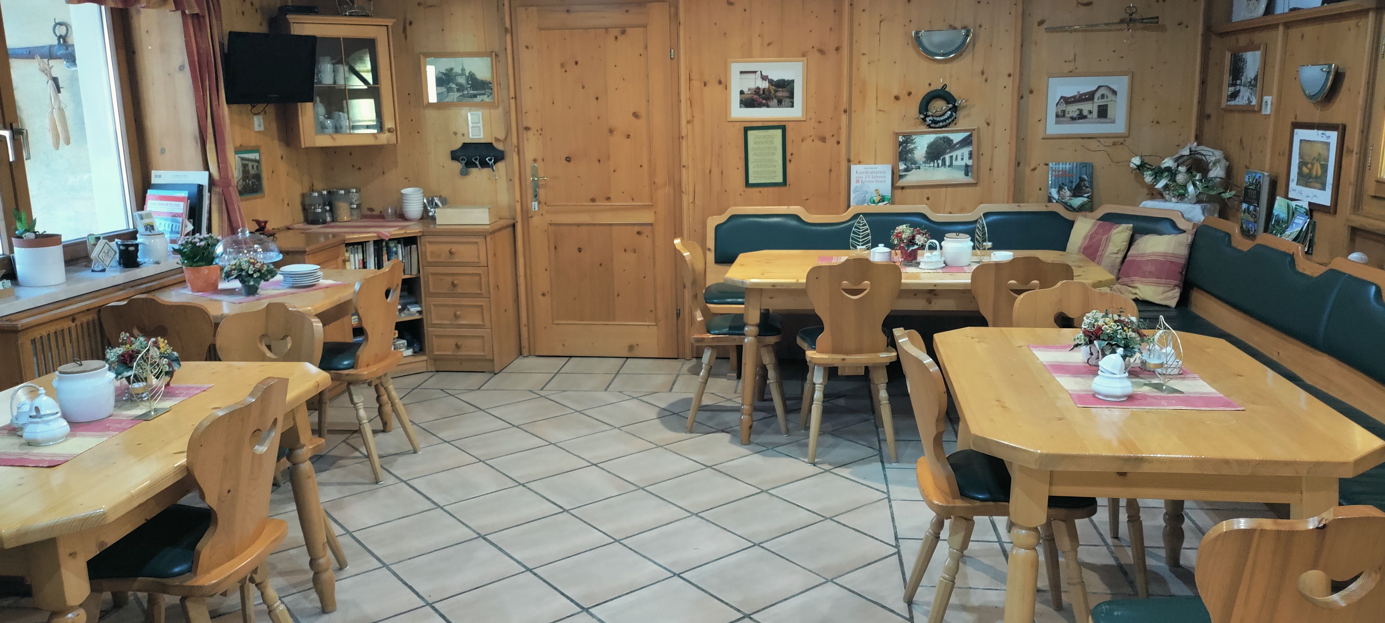 Útulná snídaňová místnost s dřevěným nábytkem a dekoracemi.