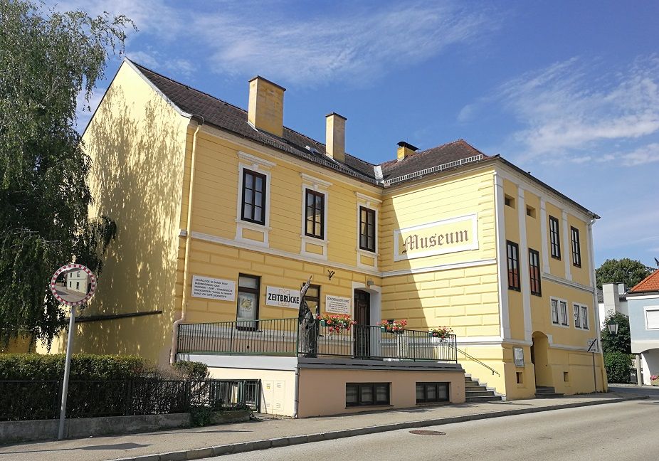 Žlutá budova s nápisy "Museum" a "Zeitbrücke".