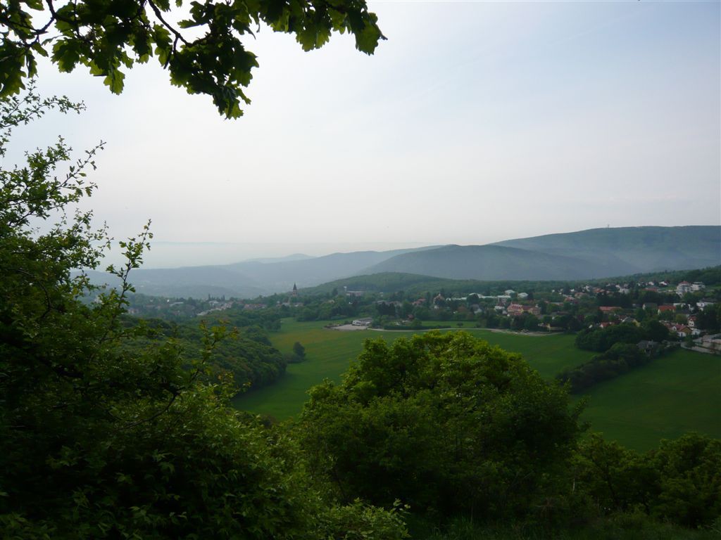 Pohled na Gießhübl se zelenými kopci a stromy v popředí.