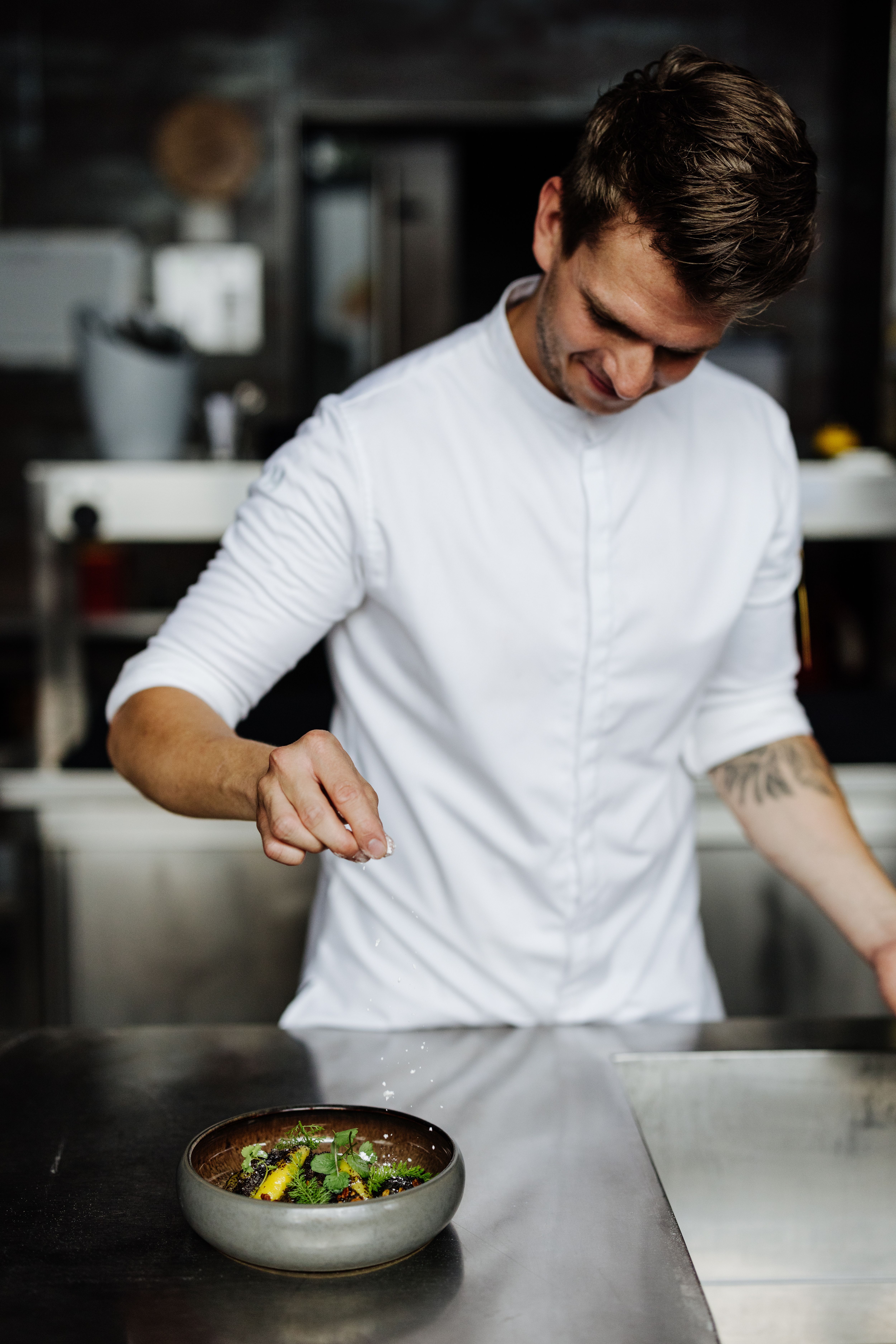Elegantní restaurace s kulatými stoly, bílými ubrusy a tlumeným osvětlením.