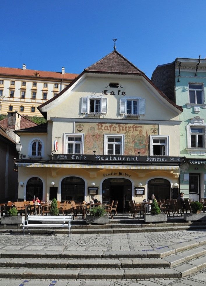 Historická budova s kavárnou a restaurací v přízemí.