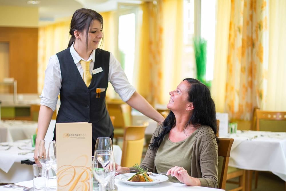 Servírka obsluhuje ženu v restauraci.