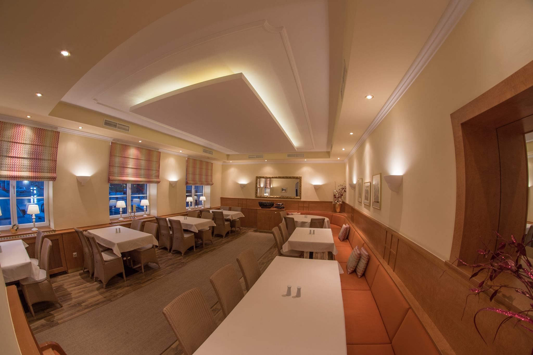 Elegantní restaurace s prostřenými stoly, teplým osvětlením a stylovou výzdobou.