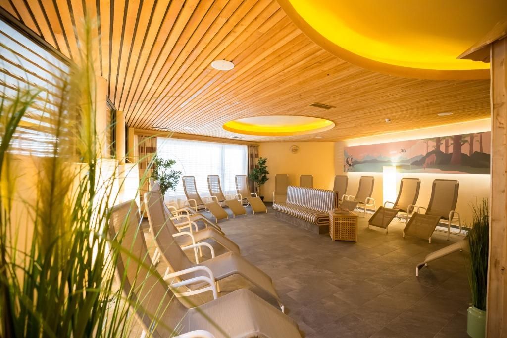 Moderní sauna s lehátky a dřevěnými prvky v hotelu JUFA Annaberg.