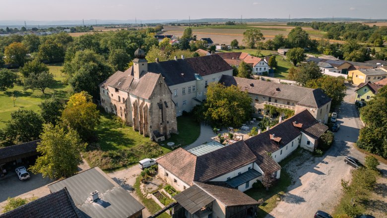 Letecký pohled na panství Oberstockstall s historickými budovami a okolní zelení.