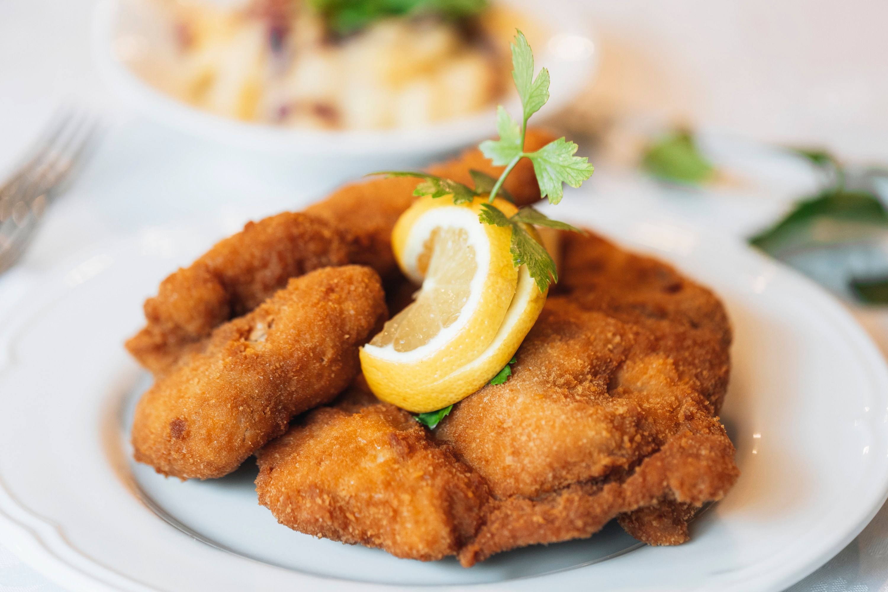 Pečené kuře s plátkem citronu a petrželkou na talíři.